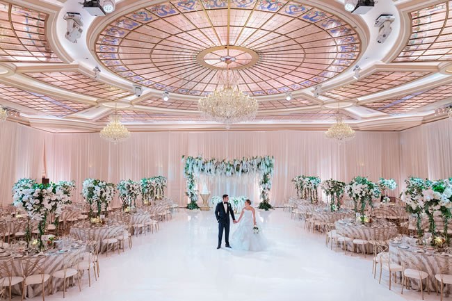 A couple holds hands in a luxe wedding reception at Taglyan Complex in Los Angeles